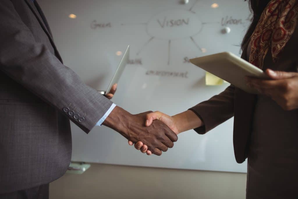 Two people shaking hands to close a deal